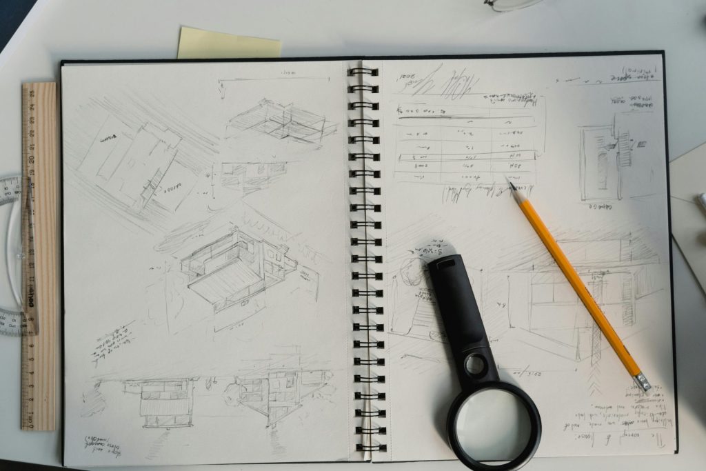 Croquis architecturaux détaillés avec outils de dessin sur un bureau, parfaits pour les projets de conception.
